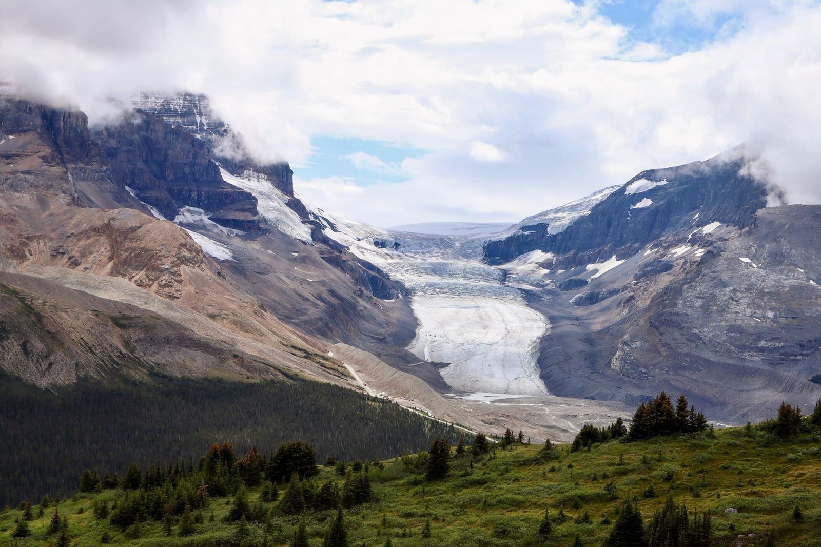 The Athabasca Glacier flows down from the Columbia Icefield between rugged mountains in Jasper National Park.